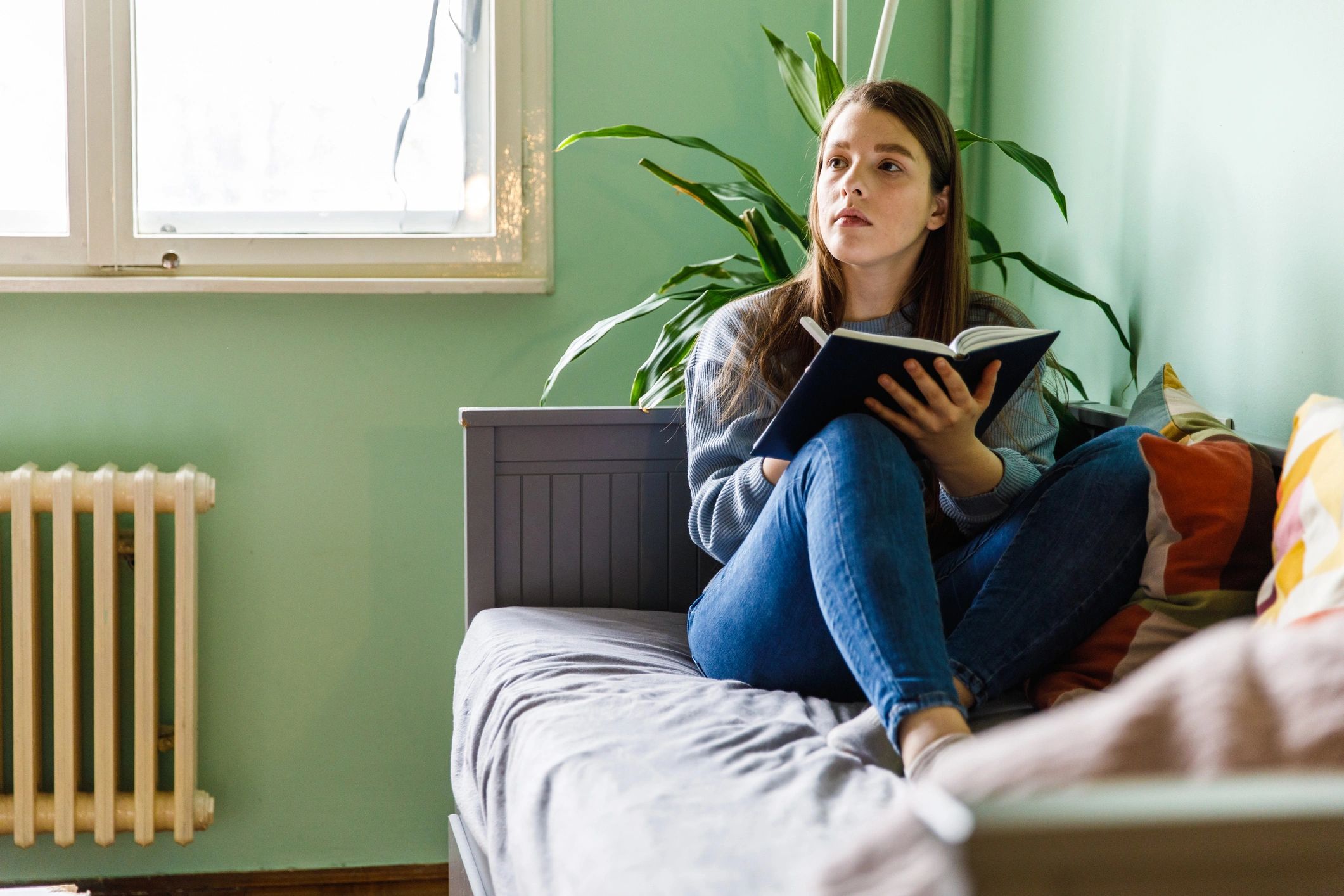 Woman reflecting while writing in a diary
